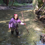 A woman wades through a river