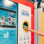 A person deposits an empty bottle into a vending machine