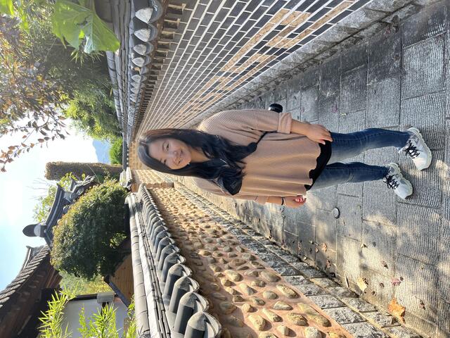 Noelle Guernsey standing in front of a stone wall