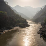 View of a river from ground level in a deep valley surrounded by mountains