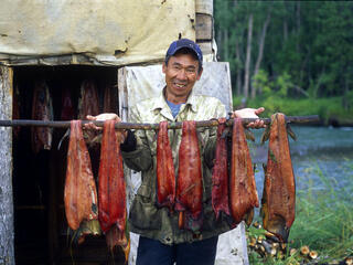 kamchatka salmon fisherman in front of smoking cabin