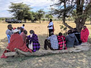 People gather under a tree to discuss data for the Climate Crowd