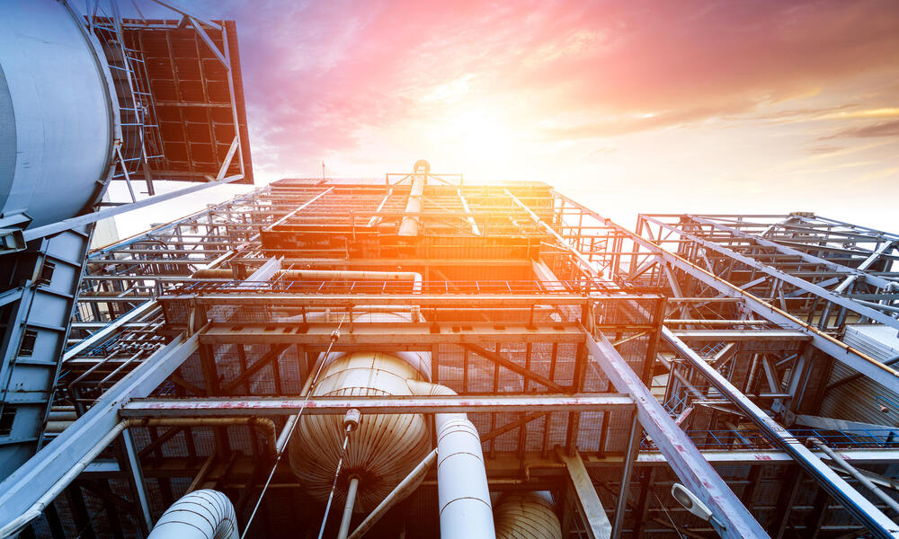 Internal structure of a larger thermal power plant with metal pieces and a bright sky 