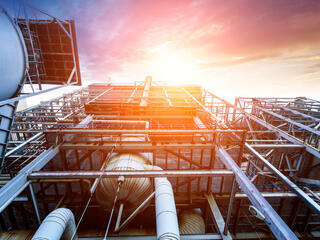 Internal structure of a larger thermal power plant with metal pieces and a bright sky 