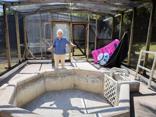 Zoe Walker stands behind a concrete rehabilitation pool that is currently empty.