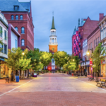 a brick paved street lined with trees and buildings